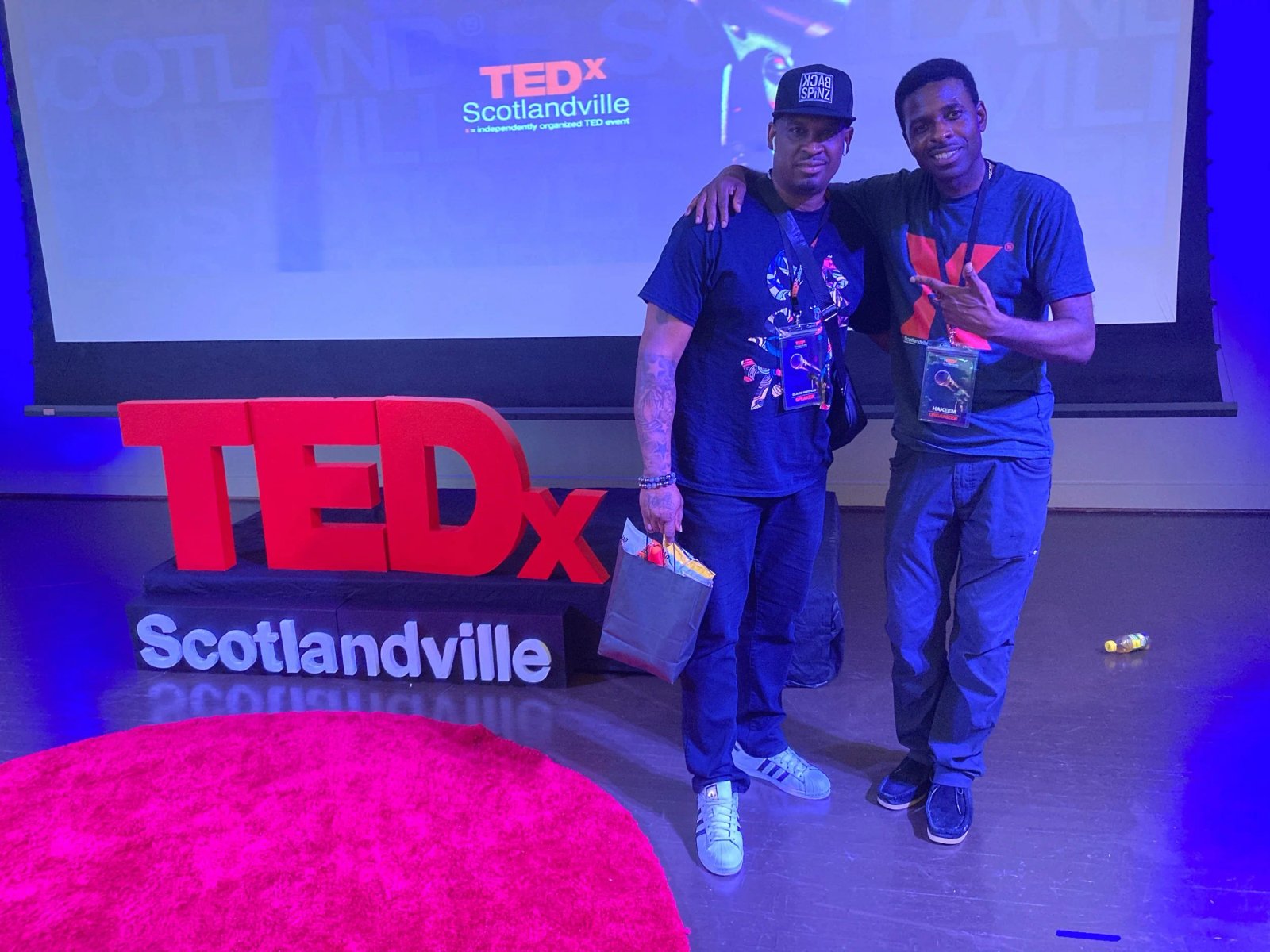 One of the TEDx Talkers and music educator Claude Whitfield and TEDxScotlandville Co-Organizer and producer Hakeem Khaaliq pose on stage after the successful event.